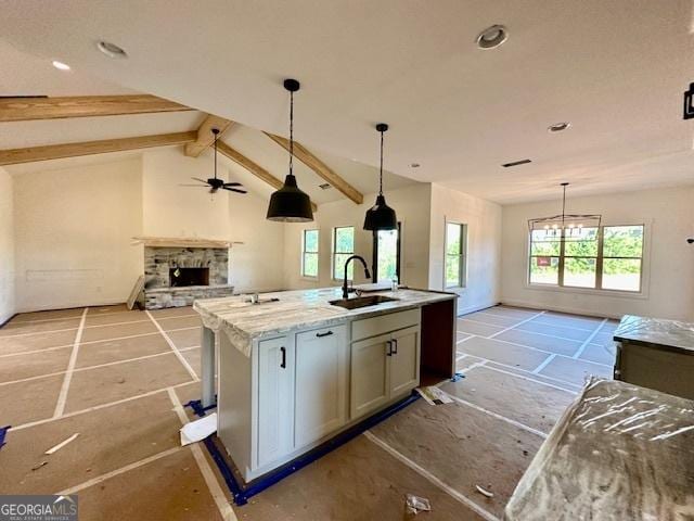 3609 Youngs Mill Rd, Hogansville, GA 30230 - kitchen with open floor plan, a stone fireplace, a center island with sink, a ceiling fan, and pendant lighting