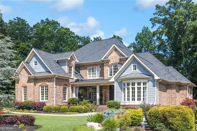 217 Fernwood Pl, Woodstock, GA 30188 - view of front of property with brick siding, a front lawn, a standing seam roof, a shingled roof, and a metal roof