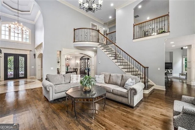 217 Fernwood Pl, Woodstock, GA 30188 - living room featuring arched walkways, a chandelier, a high ceiling, stairs, and french doors