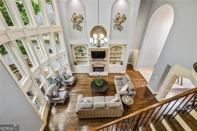 217 Fernwood Pl, Woodstock, GA 30188 - living area featuring a high ceiling, built in features, wood finished floors, arched walkways, and a chandelier