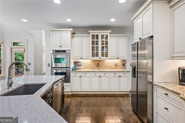 217 Fernwood Pl, Woodstock, GA 30188 - kitchen featuring appliances with stainless steel finishes, dark wood-style flooring, decorative backsplash, white cabinets, and recessed lighting