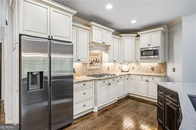 217 Fernwood Pl, Woodstock, GA 30188 - kitchen with appliances with stainless steel finishes, dark wood-type flooring, light stone countertops, tasteful backsplash, and crown molding
