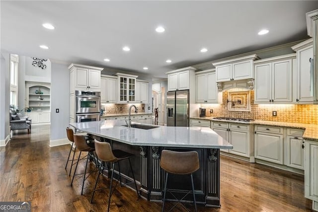 217 Fernwood Pl, Woodstock, GA 30188 - kitchen with stainless steel appliances, recessed lighting, a kitchen bar, backsplash, and light stone countertops
