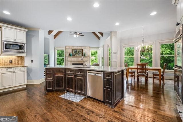 217 Fernwood Pl, Woodstock, GA 30188 - kitchen with appliances with stainless steel finishes, a ceiling fan, decorative backsplash, dark brown cabinetry, and healthy amount of natural light