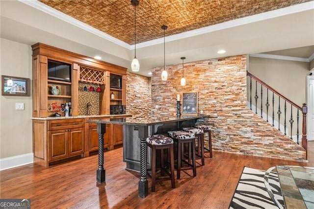 217 Fernwood Pl, Woodstock, GA 30188 - indoor wet bar featuring wood finished floors, hanging light fixtures, an ornate ceiling, crown molding, and stairs