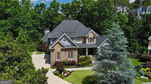 217 Fernwood Pl, Woodstock, GA 30188 - craftsman-style home with driveway, a front lawn, a chimney, covered porch, and a standing seam roof