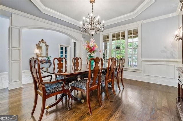 217 Fernwood Pl, Woodstock, GA 30188 - dining space with a chandelier, dark wood finished floors, a raised ceiling, crown molding, and a wainscoted wall