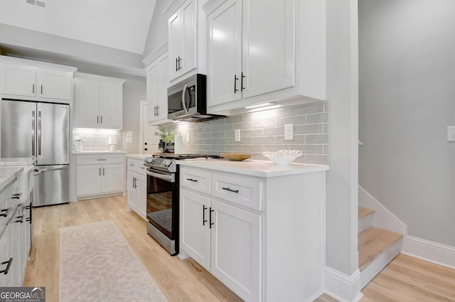 192 Greyfairs Ave, Senoia, GA 30276 - kitchen with appliances with stainless steel finishes, light wood finished floors, white cabinetry, light countertops, and lofted ceiling