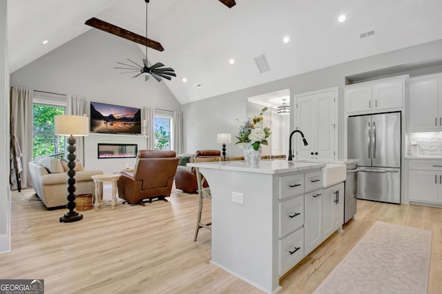 192 Greyfairs Ave, Senoia, GA 30276 - kitchen with stainless steel appliances, high vaulted ceiling, healthy amount of natural light, light countertops, and a center island with sink