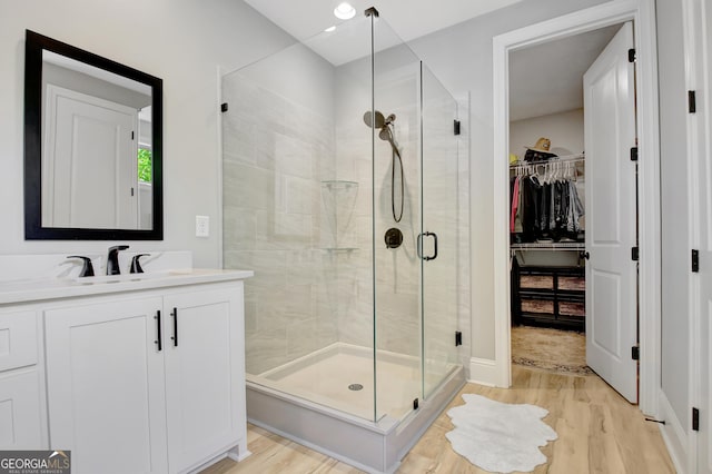 192 Greyfairs Ave, Senoia, GA 30276 - bathroom featuring wood finished floors, a stall shower, vanity, a spacious closet, and recessed lighting