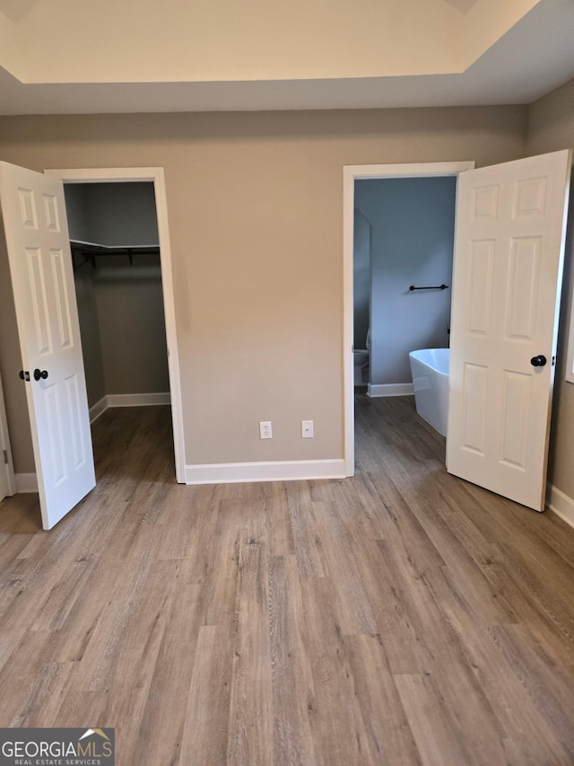 388 Kay Dr, Winder, GA 30680 - unfurnished bedroom with a walk in closet, wood finished floors, and a closet
