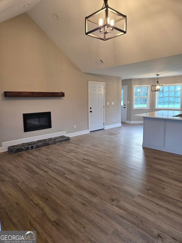 388 Kay Dr, Winder, GA 30680 - unfurnished living room featuring a chandelier, dark wood-style flooring, a glass covered fireplace, recessed lighting, and high vaulted ceiling