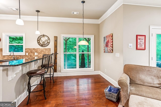 5717 Meadow View Dr, Jefferson, GA 30549 - kitchen featuring ornamental molding, dark wood-style floors, a breakfast bar area, healthy amount of natural light, and dark stone counters