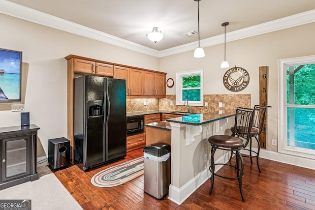 5717 Meadow View Dr, Jefferson, GA 30549 - kitchen with black appliances, a peninsula, a breakfast bar, dark wood finished floors, and crown molding
