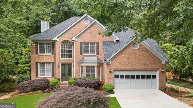878 Treadstone Overlook, Suwanee, GA 30024 - view of front facade featuring brick siding, a chimney, concrete driveway, a garage, and roof with shingles