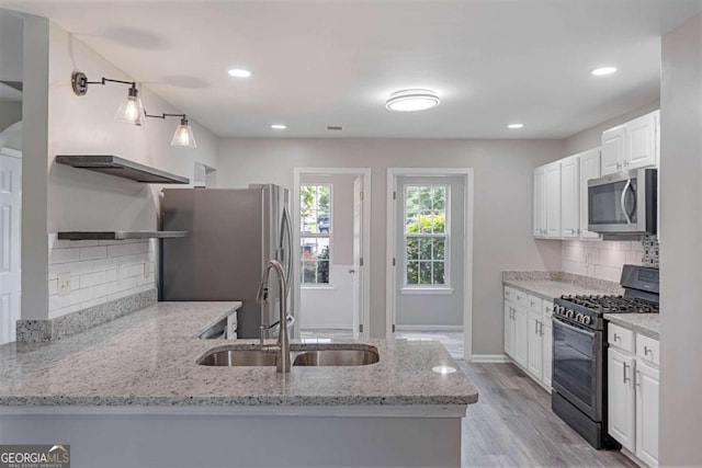1455 Holleybrooke Dr, Alpharetta, GA 30004 - kitchen with stainless steel appliances, open shelves, light stone counters, light wood-type flooring, and white cabinetry