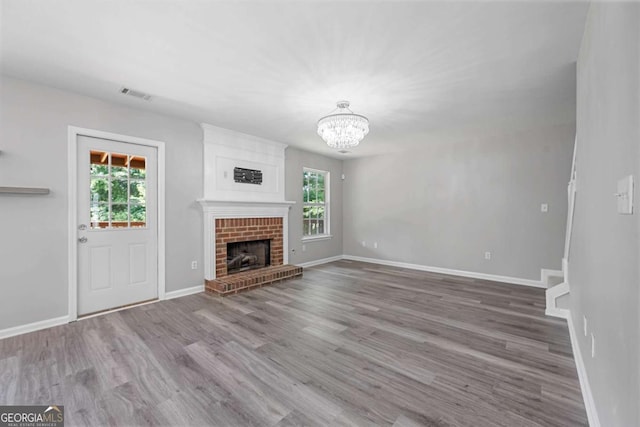1455 Holleybrooke Dr, Alpharetta, GA 30004 - unfurnished living room with healthy amount of natural light, a chandelier, and wood finished floors