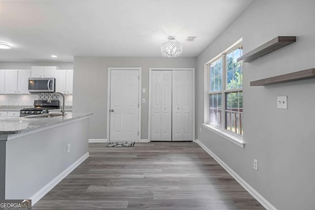 1455 Holleybrooke Dr, Alpharetta, GA 30004 - kitchen featuring stainless steel microwave, range, white cabinetry, dark wood-style floors, and backsplash