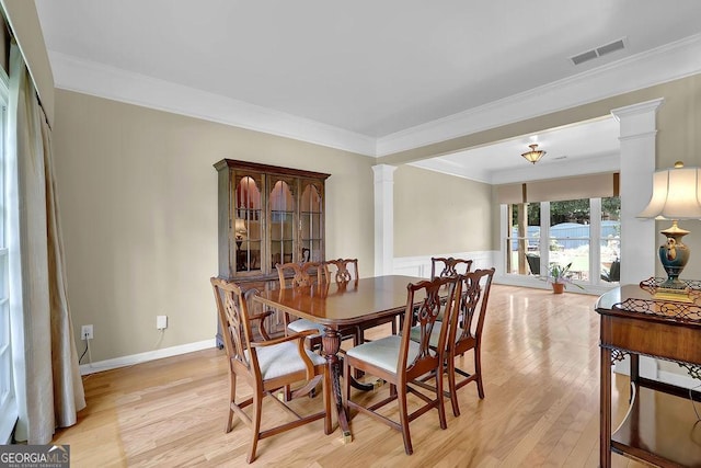 7325 Brookwood Way, Cumming, GA 30041 - dining space featuring decorative columns, light wood-type flooring, crown molding, and a wainscoted wall