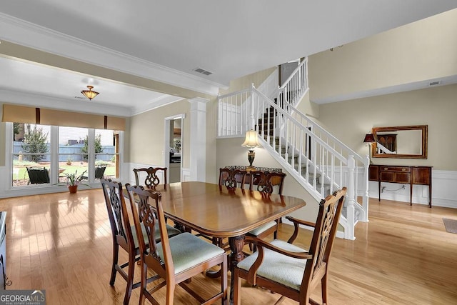 7325 Brookwood Way, Cumming, GA 30041 - dining room with light wood-style flooring, ornate columns, stairway, crown molding, and wainscoting