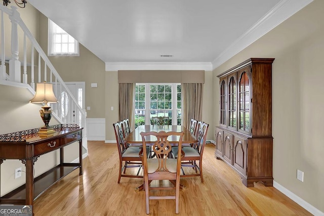 7325 Brookwood Way, Cumming, GA 30041 - dining space featuring healthy amount of natural light, stairs, light wood-type flooring, and ornamental molding