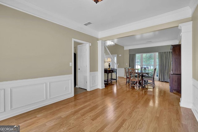 7325 Brookwood Way, Cumming, GA 30041 - dining area with crown molding, light wood-style flooring, a decorative wall, decorative columns, and a wainscoted wall