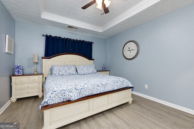 67 Granite Ct, Dallas, GA 30132 - bedroom with wood finished floors, a textured ceiling, a raised ceiling, ornamental molding, and a ceiling fan