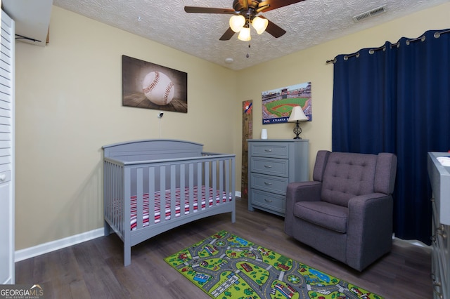 67 Granite Ct, Dallas, GA 30132 - bedroom with wood finished floors, a crib, a textured ceiling, and a ceiling fan