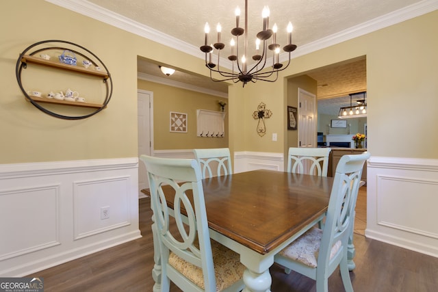 67 Granite Ct, Dallas, GA 30132 - dining room featuring a chandelier, a textured ceiling, wood finished floors, ornamental molding, and wainscoting