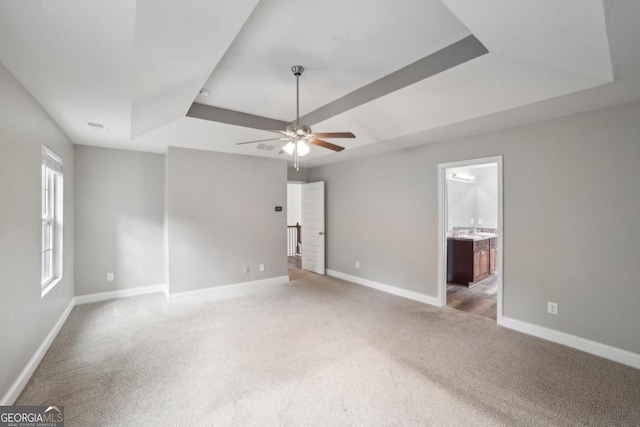 176 Windy Cir, Mcdonough, GA 30253 - unfurnished bedroom with a raised ceiling, light colored carpet, ensuite bath, and ceiling fan
