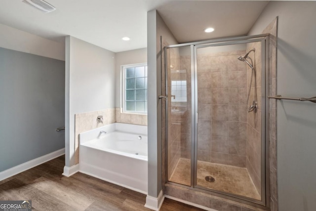 176 Windy Cir, Mcdonough, GA 30253 - bathroom featuring wood finished floors, a garden tub, a stall shower, and recessed lighting