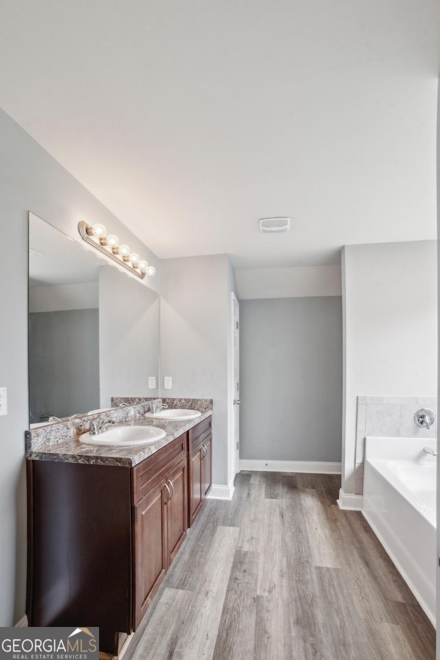 176 Windy Cir, Mcdonough, GA 30253 - full bath with wood finished floors, a garden tub, and double vanity