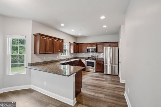 176 Windy Cir, Mcdonough, GA 30253 - kitchen featuring appliances with stainless steel finishes, wood finished floors, decorative backsplash, a peninsula, and recessed lighting
