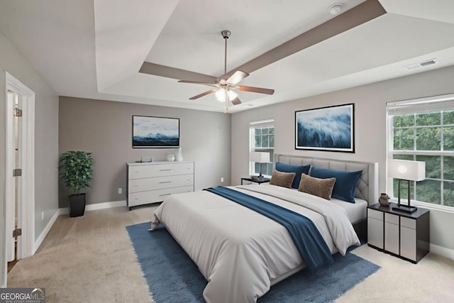 176 Windy Cir, Mcdonough, GA 30253 - bedroom with light colored carpet, a tray ceiling, and a ceiling fan