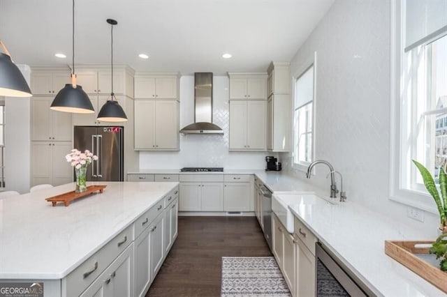 385 Rowes Cir, Alpharetta, GA 30009 - kitchen featuring appliances with stainless steel finishes, wall chimney range hood, dark wood-style flooring, decorative light fixtures, and a center island