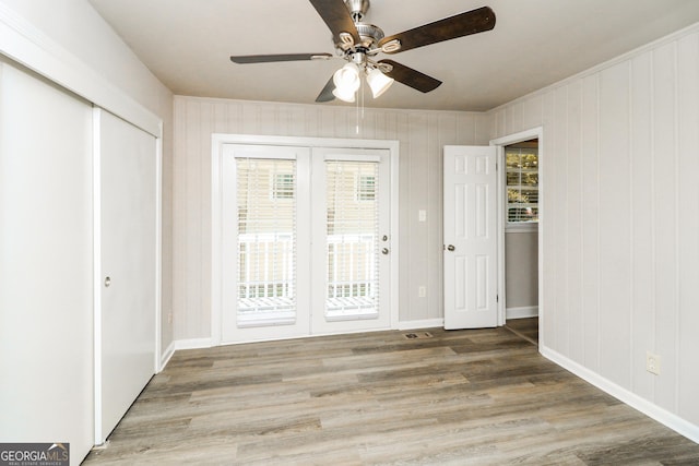 1947 Main St NW, Atlanta, GA 30318 - unfurnished bedroom featuring access to outside, wood finished floors, a ceiling fan, and a closet