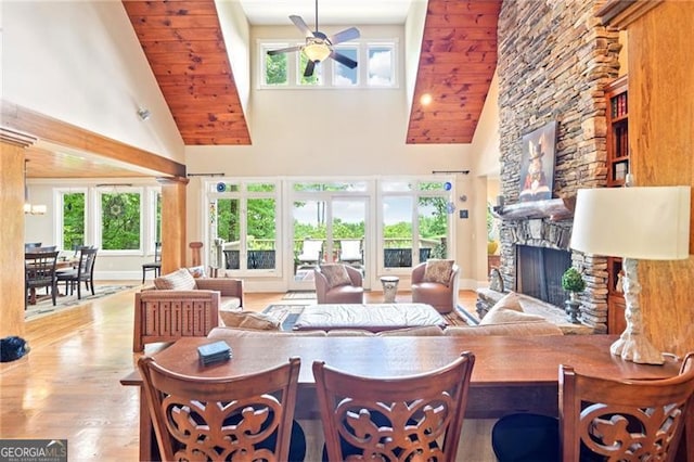 44 Sassafras Rdg, Big Canoe, GA 30143 - living room with high vaulted ceiling, ceiling fan, a stone fireplace, wood finished floors, and healthy amount of natural light