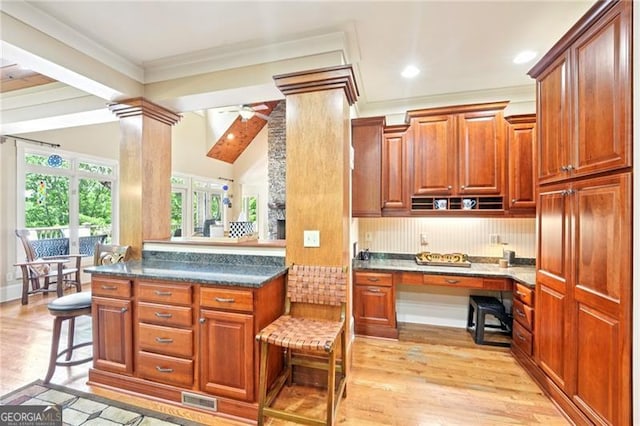 44 Sassafras Rdg, Big Canoe, GA 30143 - kitchen with built in study area, light wood-style floors, dark countertops, a kitchen breakfast bar, and a ceiling fan