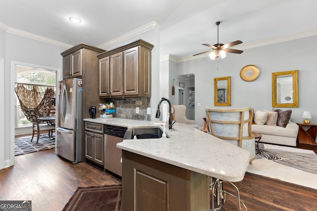 300 Bridgehampton Way, Perry, GA 31069 - kitchen featuring appliances with stainless steel finishes, a peninsula, crown molding, ceiling fan, and light stone countertops