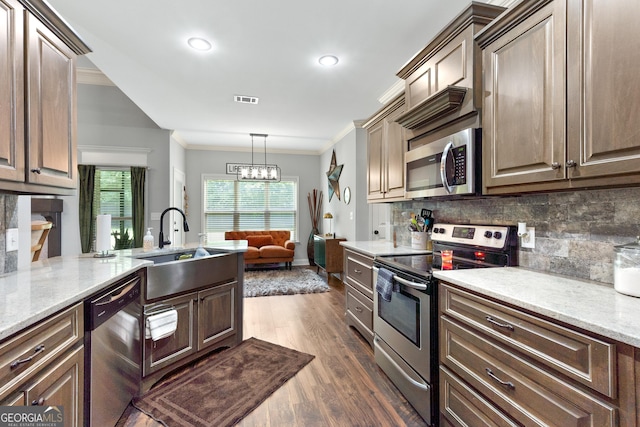 300 Bridgehampton Way, Perry, GA 31069 - kitchen with appliances with stainless steel finishes, crown molding, tasteful backsplash, dark wood-style floors, and light stone countertops
