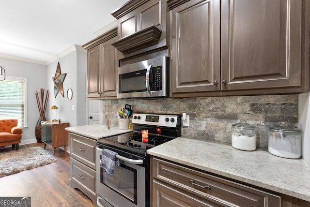 300 Bridgehampton Way, Perry, GA 31069 - kitchen featuring appliances with stainless steel finishes, ornamental molding, decorative backsplash, dark wood finished floors, and dark brown cabinets