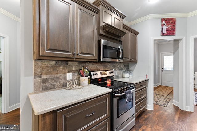 300 Bridgehampton Way, Perry, GA 31069 - kitchen with stainless steel appliances, crown molding, light countertops, dark wood finished floors, and decorative backsplash