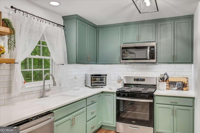 425 Shelby Ln, Hiram, GA 30141 - kitchen with appliances with stainless steel finishes, green cabinets, light countertops, decorative backsplash, and recessed lighting