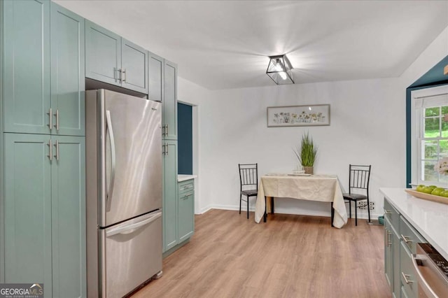 425 Shelby Ln, Hiram, GA 30141 - kitchen with appliances with stainless steel finishes, light countertops, light wood finished floors, and green cabinetry