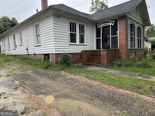 1182 Brentwood Ave, Macon, GA 31204 - view of home's exterior with a shingled roof and a chimney