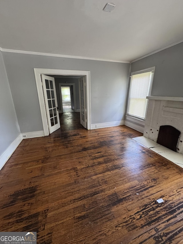 1182 Brentwood Ave, Macon, GA 31204 - unfurnished living room featuring crown molding, healthy amount of natural light, and dark wood-type flooring
