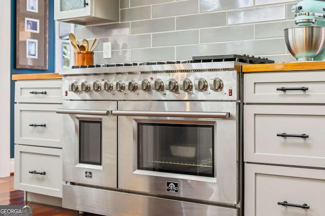 425 Starfire Ct, Suwanee, GA 30024 - kitchen view of double oven range, tasteful backsplash, and glass insert cabinets