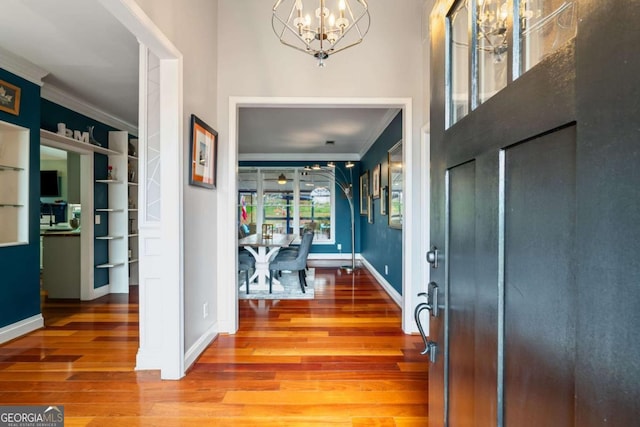 425 Starfire Ct, Suwanee, GA 30024 - entryway with crown molding, a chandelier, and wood finished floors
