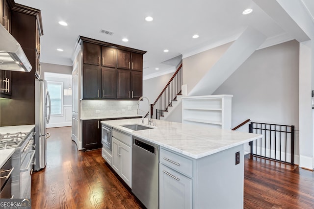 326 Brownstones Cir NE, Atlanta, GA 30312 - kitchen featuring stainless steel appliances, ornamental molding, wall chimney exhaust hood, dark wood finished floors, and light stone countertops