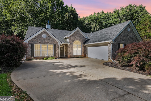 7140 Timberbrooke Dr, Gainesville, GA 30506 - view of front of home featuring roof with shingles, a garage, driveway, brick siding, and a chimney